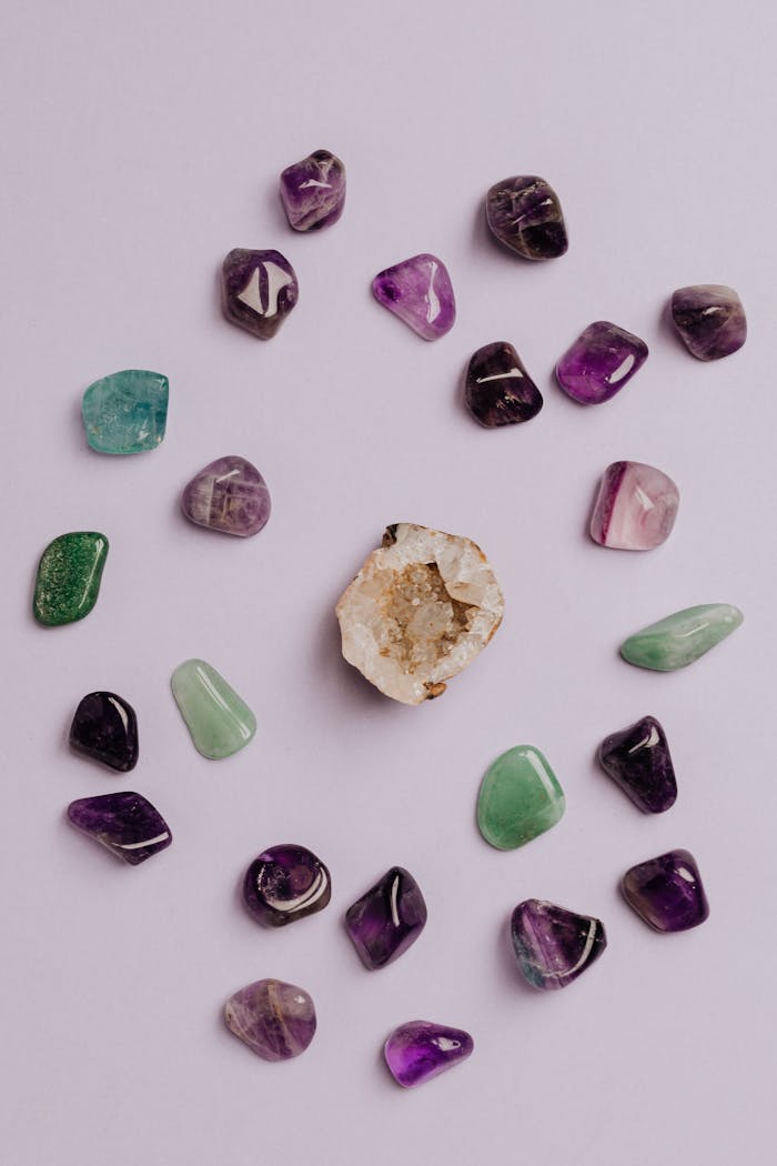 A collection of colorful tumbled gemstones artfully arranged on a neutral background.